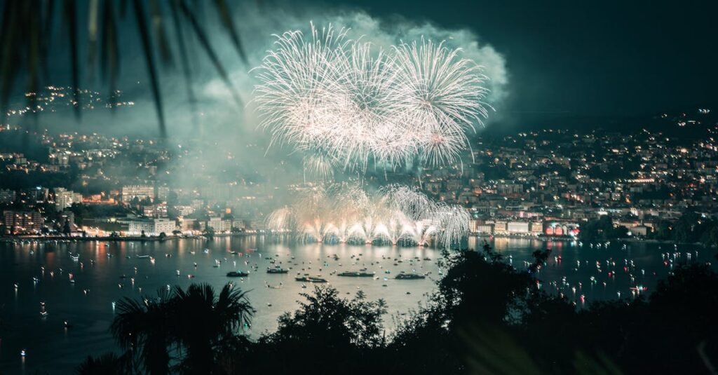 Nighttime fireworks display over Lugano, Switzerland, lighting up the lake and cityscape.