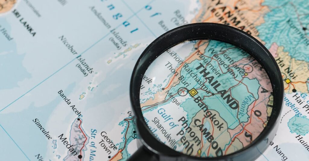 A magnifying glass highlighting Thailand on a detailed world map, ideal for travel-themed visuals.